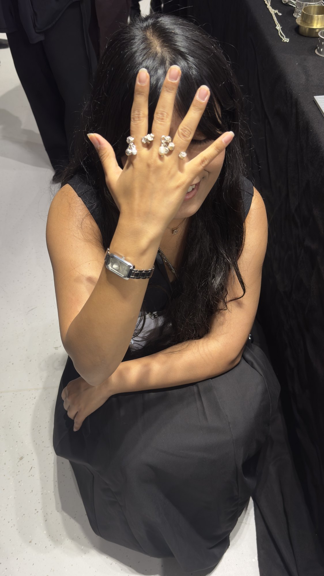 A visitor looking at silver cuffs and chains on the table.